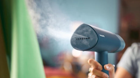 Taghareed Philips 3000 Series handheld steamer, blue, compact and foldable, for quick wrinkle removal and garment refreshing.