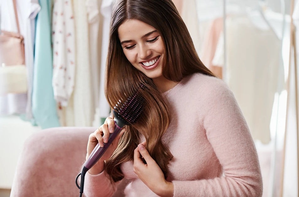 Taghareed Philips 5000 Series heated straightening brush with Keratin-infused ceramic coating, smoothing hair.