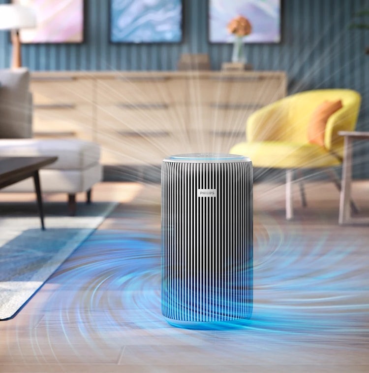 Taghareed Philips Smart Air Purifier 4200 Series AC4220/12, white and silver, with vertical slats, purifying air in a living room.