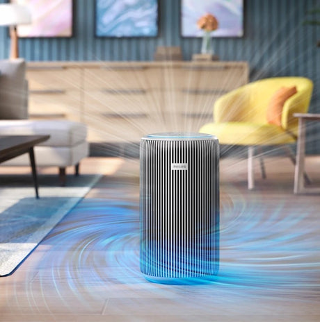 Taghareed Philips Smart Air Purifier 4200 Series AC4220/12, white and silver, with vertical slats, purifying air in a living room.