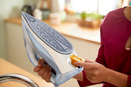 Taghareed Philips 7000 Series steam iron, light blue and grey, with SteamGlide Plus soleplate and Drip-Stop.