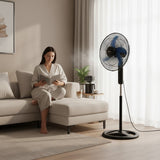 Taghareed Sona 18" black stand fan with blue blades, providing daily cooling in a living room setting.